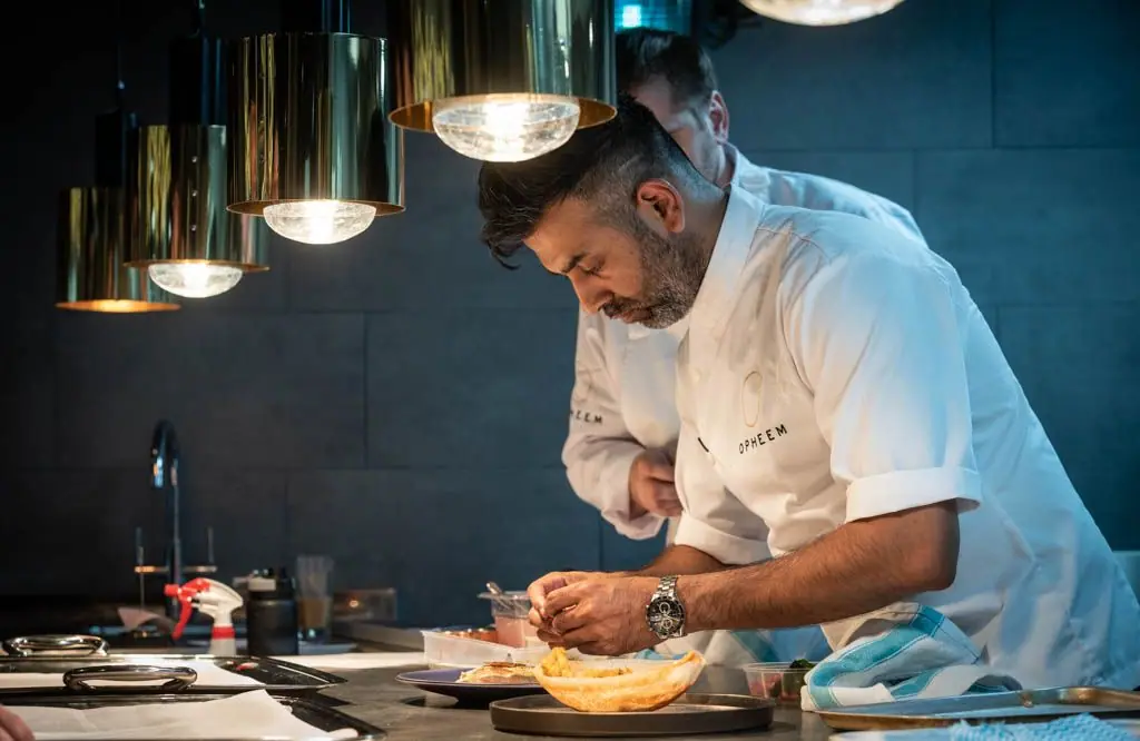 Aktar Islam plating under the kitchen lamps